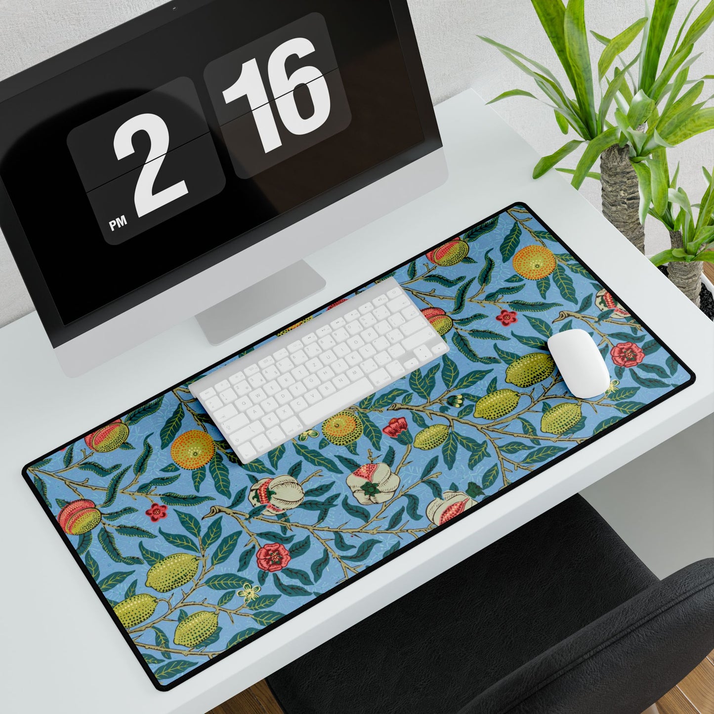 A desk mat with a floral pattern featuring various fruits, placed under a desk with a keyboard and mouse on top.