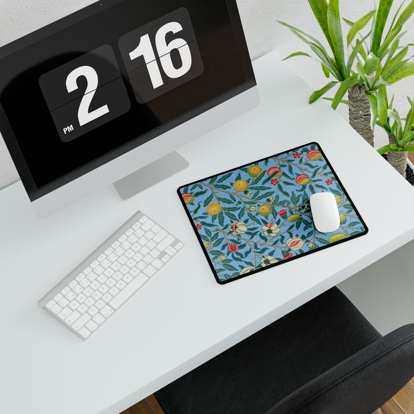 A desk mat with a floral pattern featuring various fruits, placed under a desk with a keyboard and mouse on top.