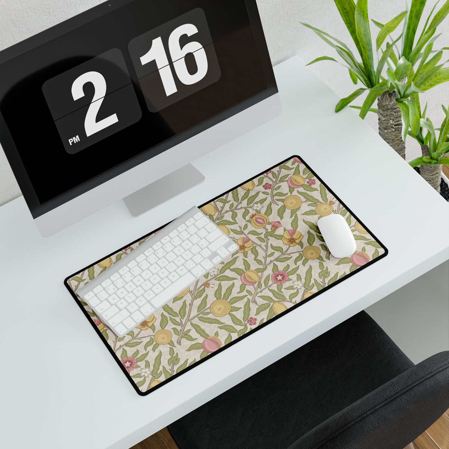 Floral patterned mouse pad on a desk with a computer and digital clock.