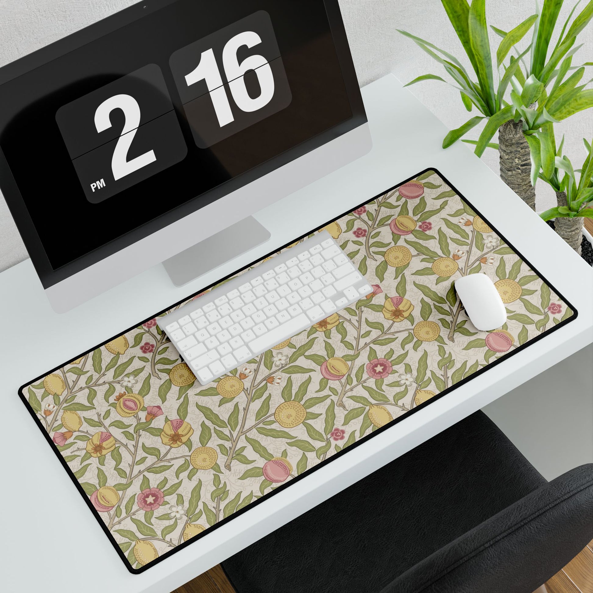 Floral desk mat on a desk with a computer and office items.