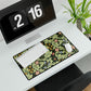 A large desk mat with a green William Morris & Co floral pattern, displayed on a desk with a keyboard and mouse, with a monitor above it.