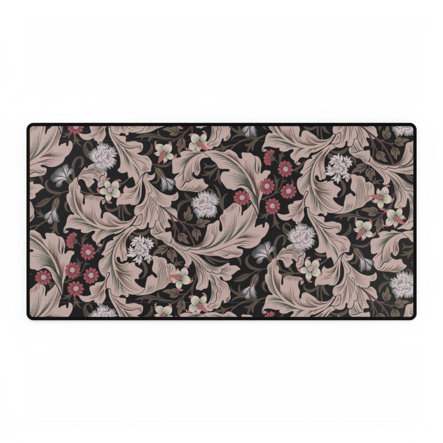 A large desk mat with a William Morris & Co floral pattern in mocha and black colours, displayed on a desk with a keyboard and mouse.