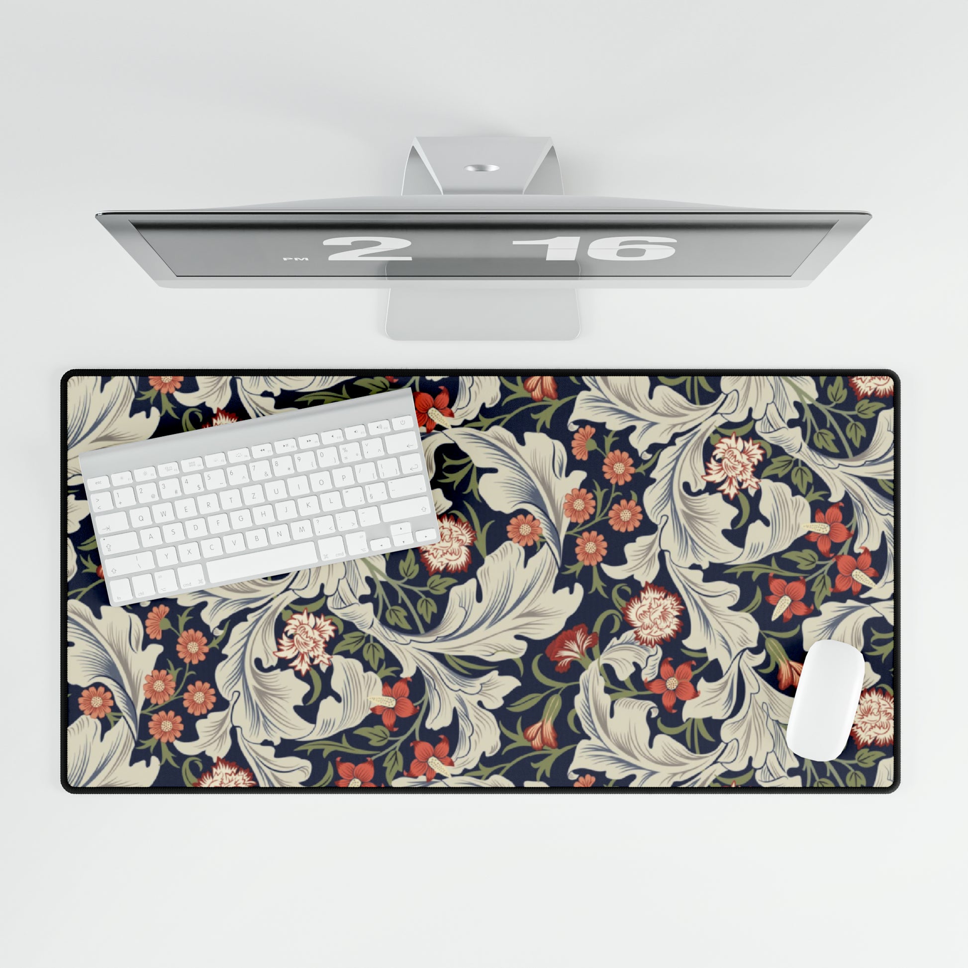 A large desk mat with a William Morris & Co floral pattern, inspired by William Morris, placed on a desk with a keyboard and mouse.
