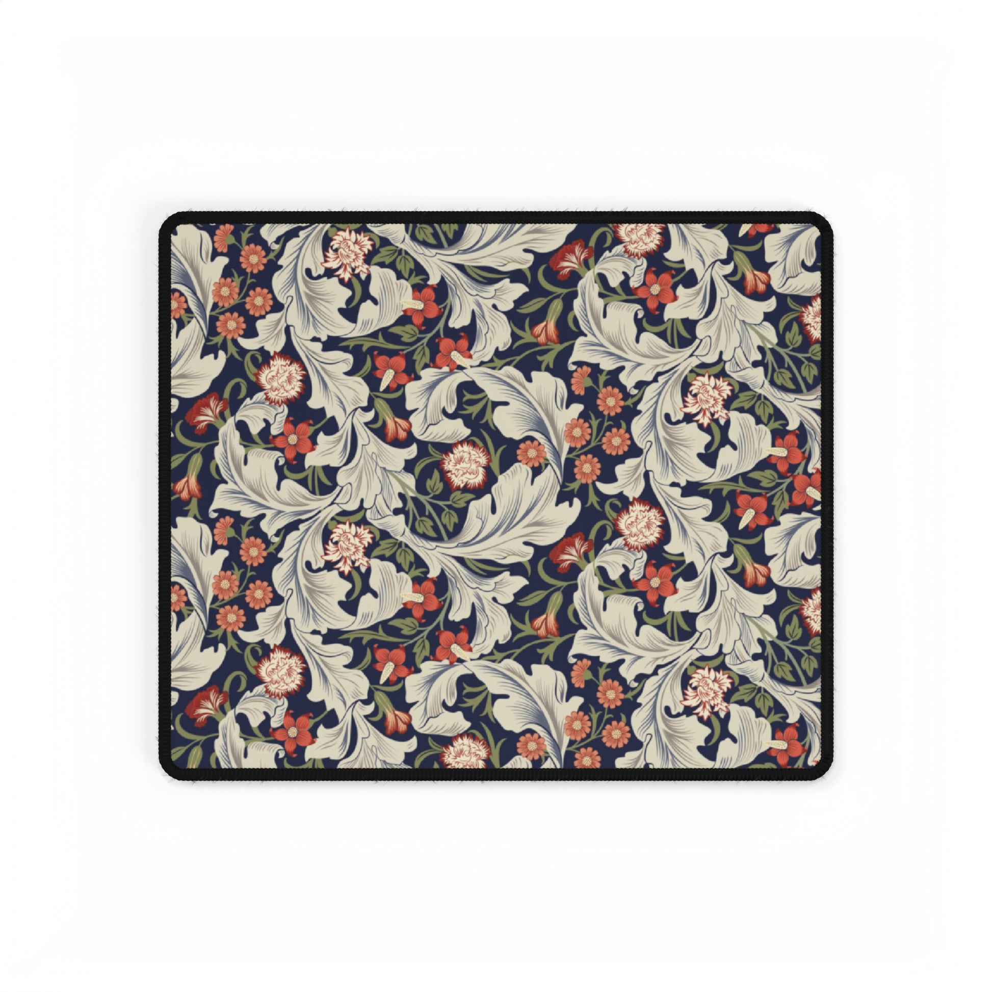 A large desk mat with a William Morris & Co floral pattern, inspired by William Morris, placed on a desk with a keyboard and mouse.