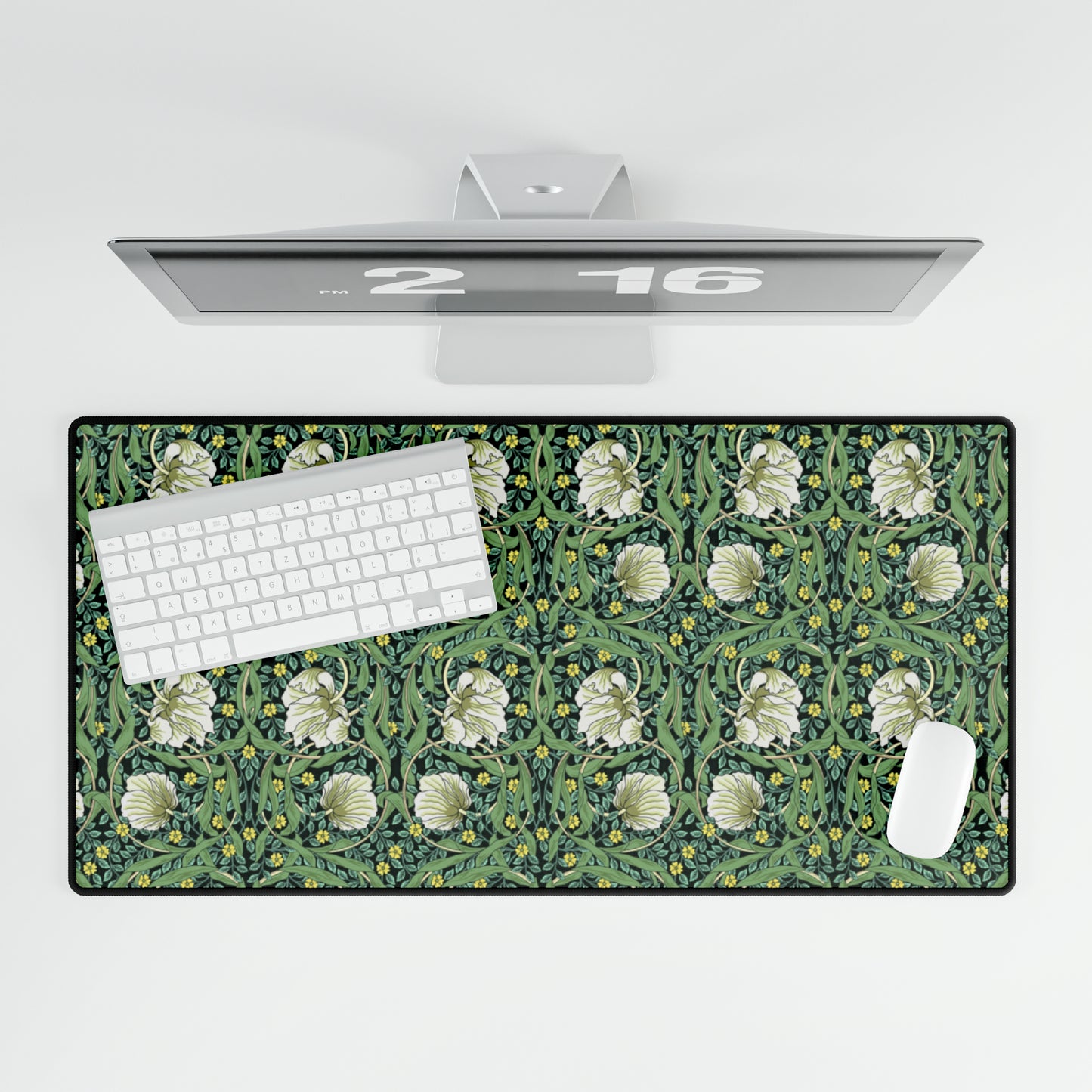A rectangular desk mat with a green floral pattern, featuring a mouse pad on top. The desk mat is placed under a whiteboard with a digital display and a keyboard.