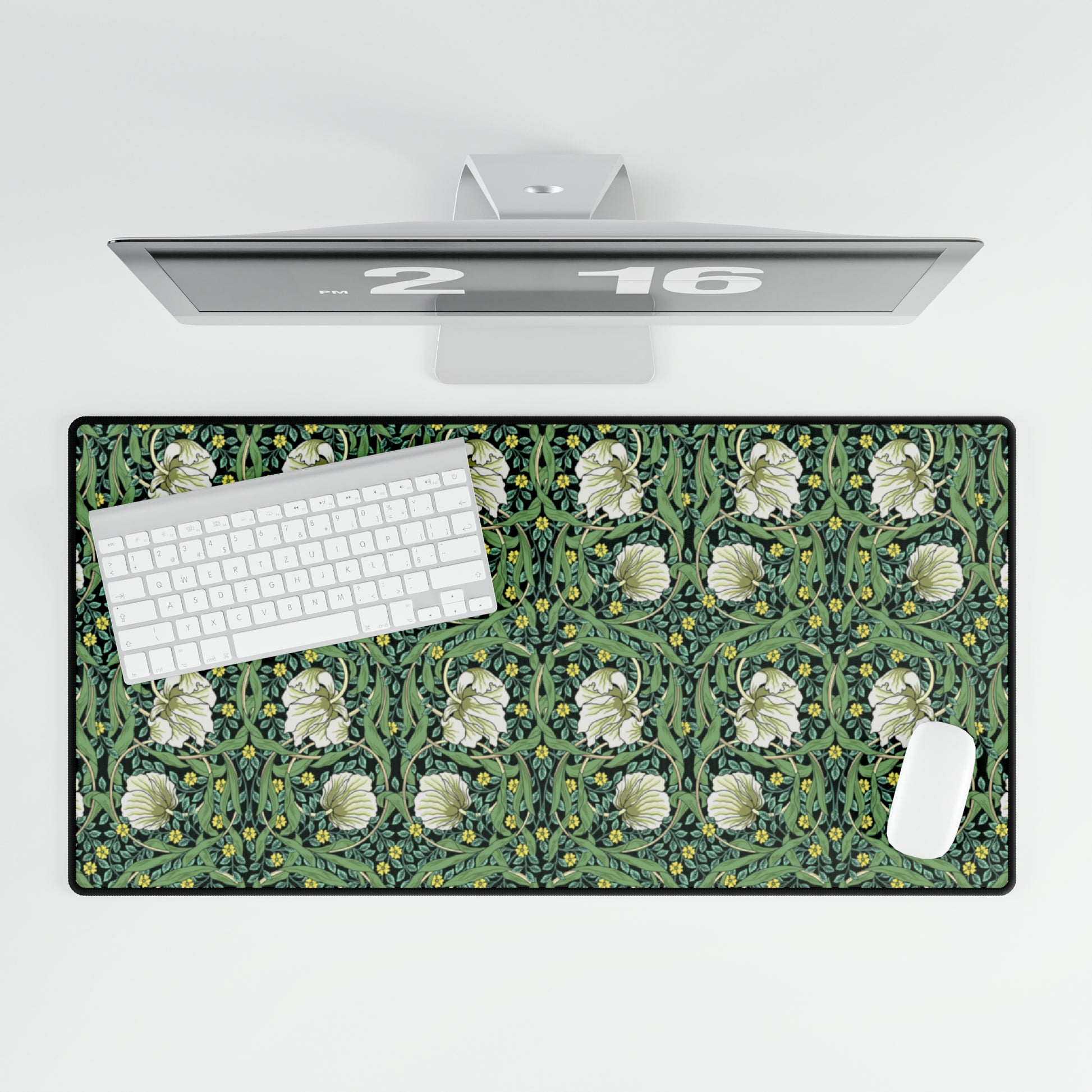 A rectangular desk mat with a green floral pattern, featuring a mouse pad on top. The desk mat is placed under a whiteboard with a digital display and a keyboard.