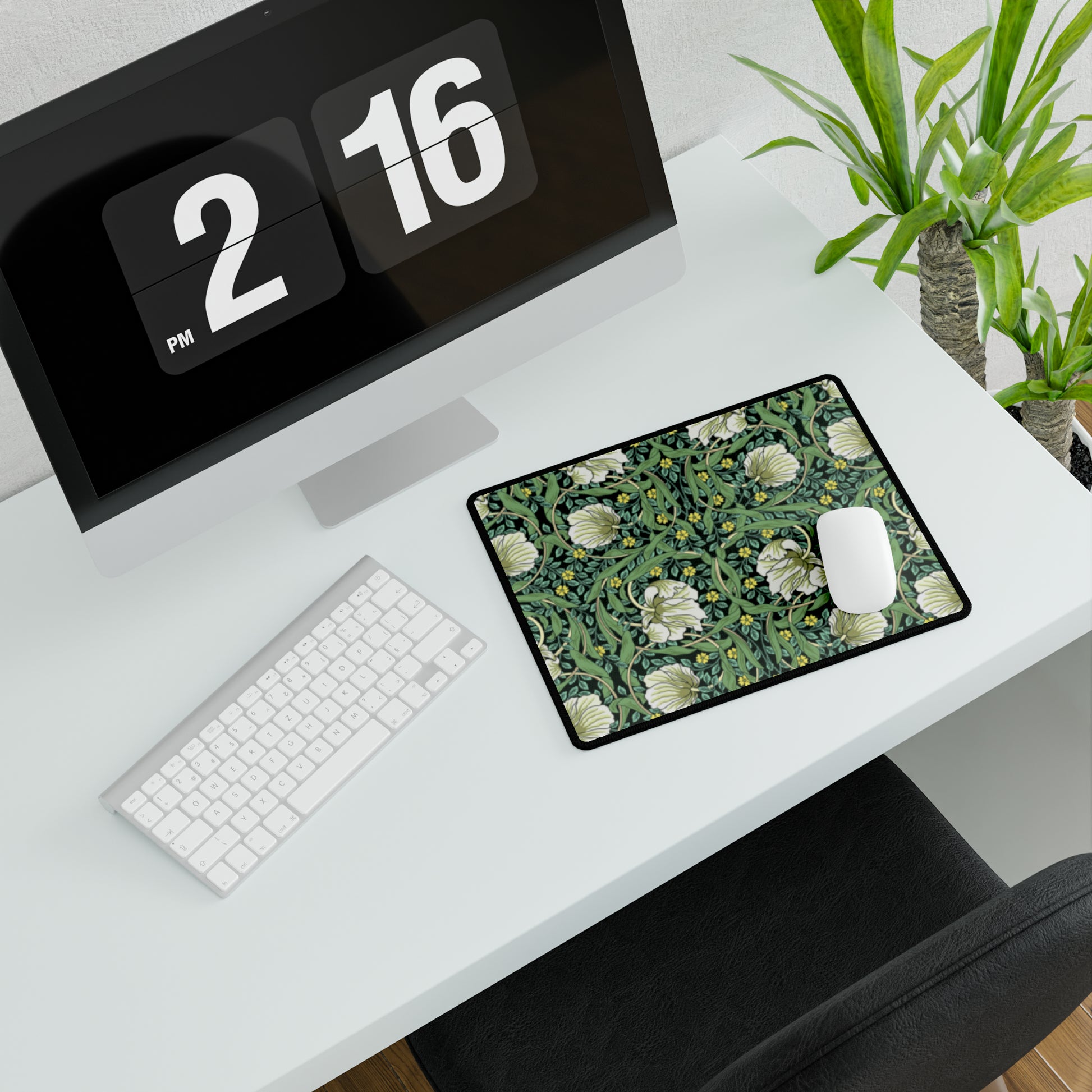 A rectangular desk mat with a green floral pattern, featuring a mouse pad on top. The desk mat is placed under a whiteboard with a digital display and a keyboard.