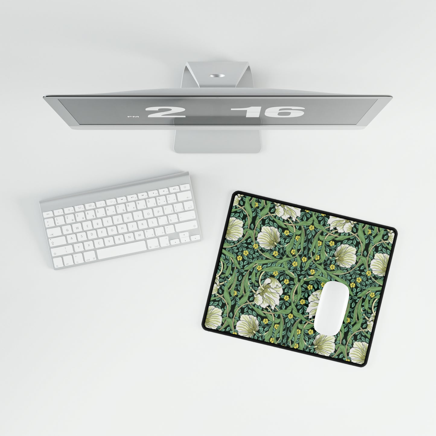 A rectangular desk mat with a green floral pattern, featuring a mouse pad on top. The desk mat is placed under a whiteboard with a digital display and a keyboard.