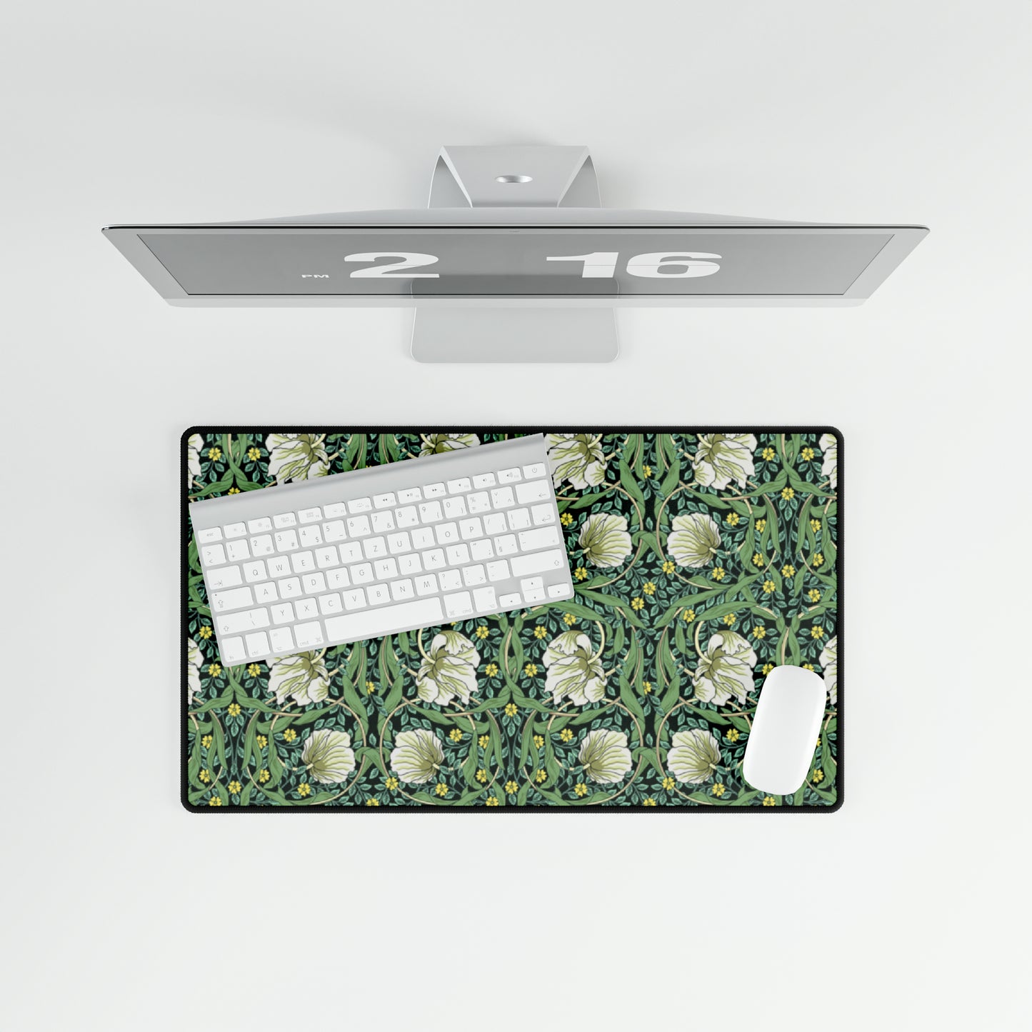 A rectangular desk mat with a green floral pattern, featuring a mouse pad on top. The desk mat is placed under a whiteboard with a digital display and a keyboard.