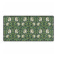 A rectangular desk mat with a green floral pattern, featuring a mouse pad on top. The desk mat is placed under a whiteboard with a digital display and a keyboard.