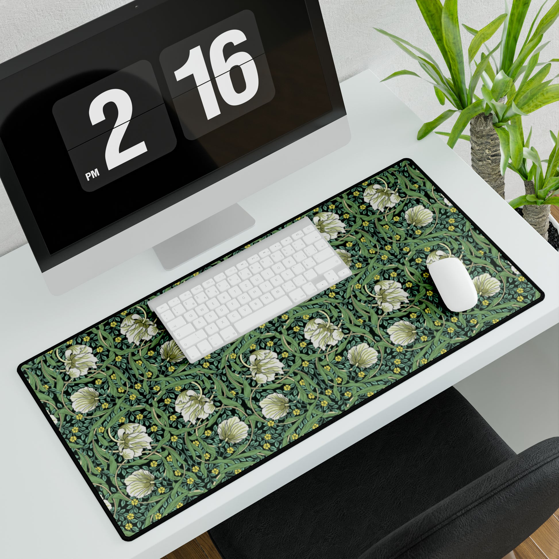A rectangular desk mat with a green floral pattern, featuring a mouse pad on top. The desk mat is placed under a whiteboard with a digital display and a keyboard.