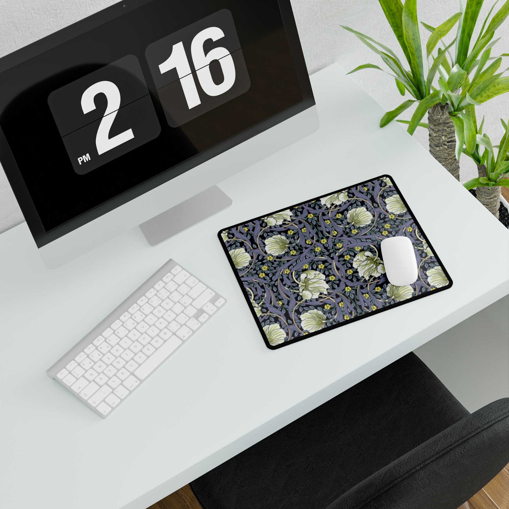 A large desk mat with a William Morris & Co floral pattern in shades of purple and green, displayed on a desk with a keyboard and mouse.
