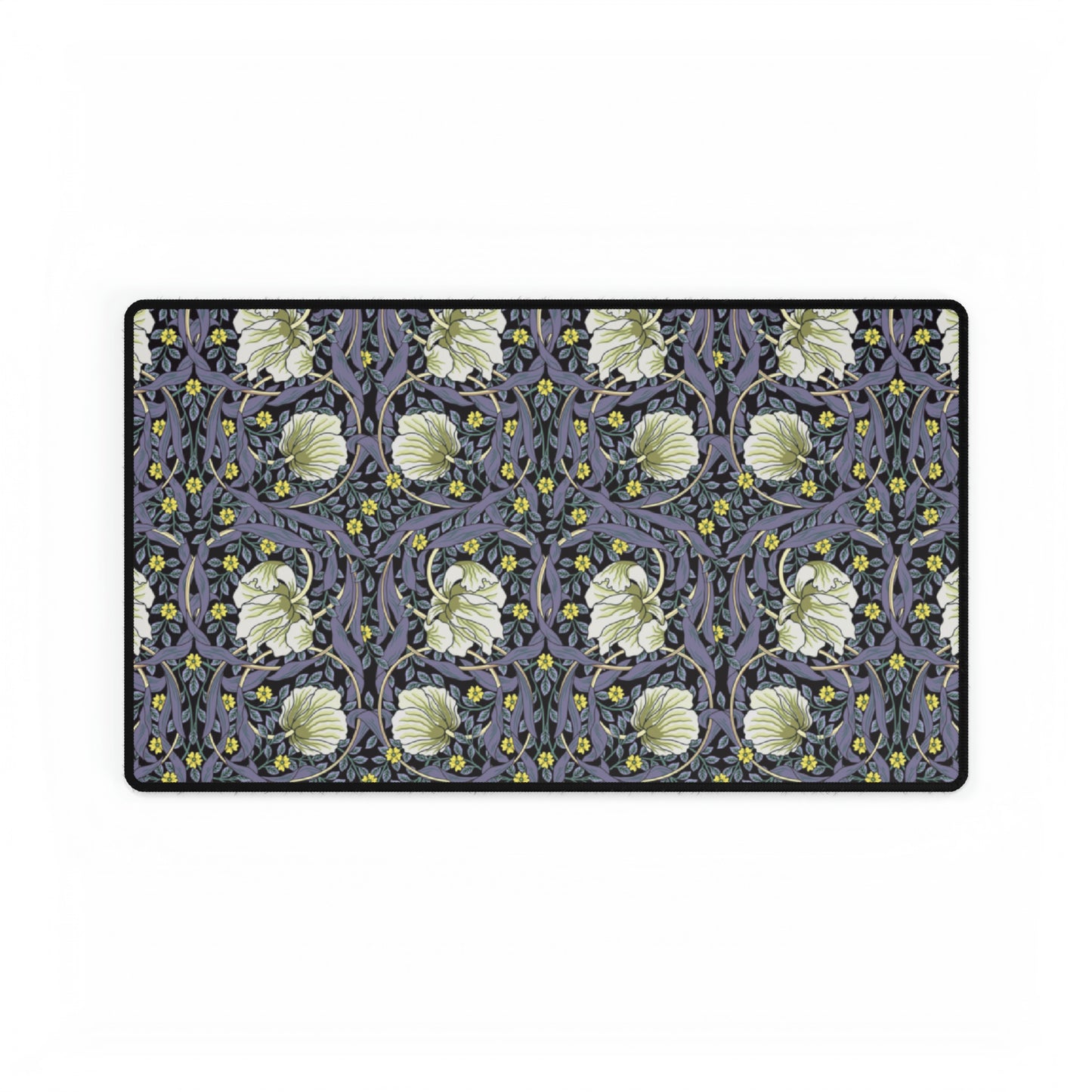 A large desk mat with a William Morris & Co floral pattern in shades of purple and green, displayed on a desk with a keyboard and mouse.