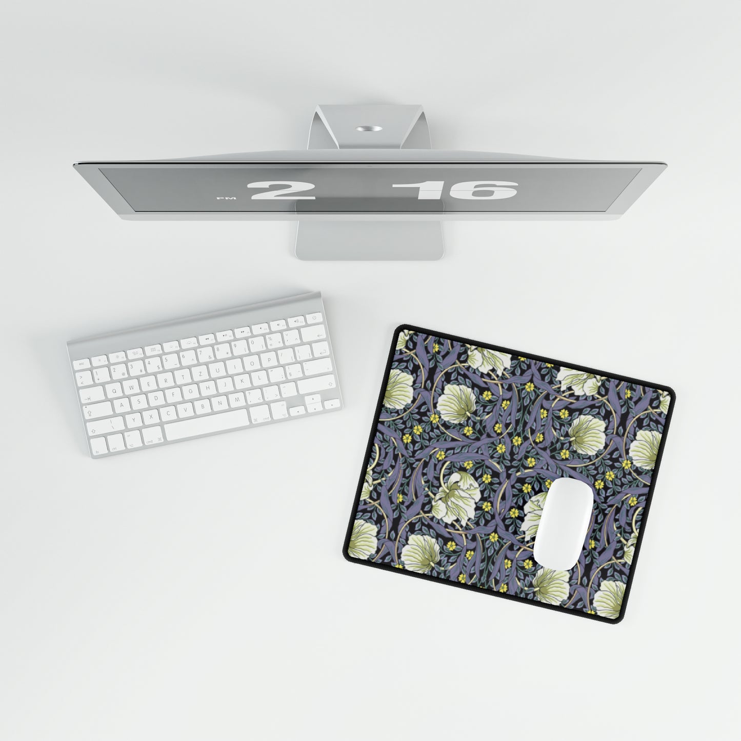 A large desk mat with a floral pattern in shades of purple and green, displayed on a desk with a keyboard and mouse.