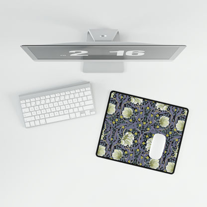 A large desk mat with a floral pattern in shades of purple and green, displayed on a desk with a keyboard and mouse.