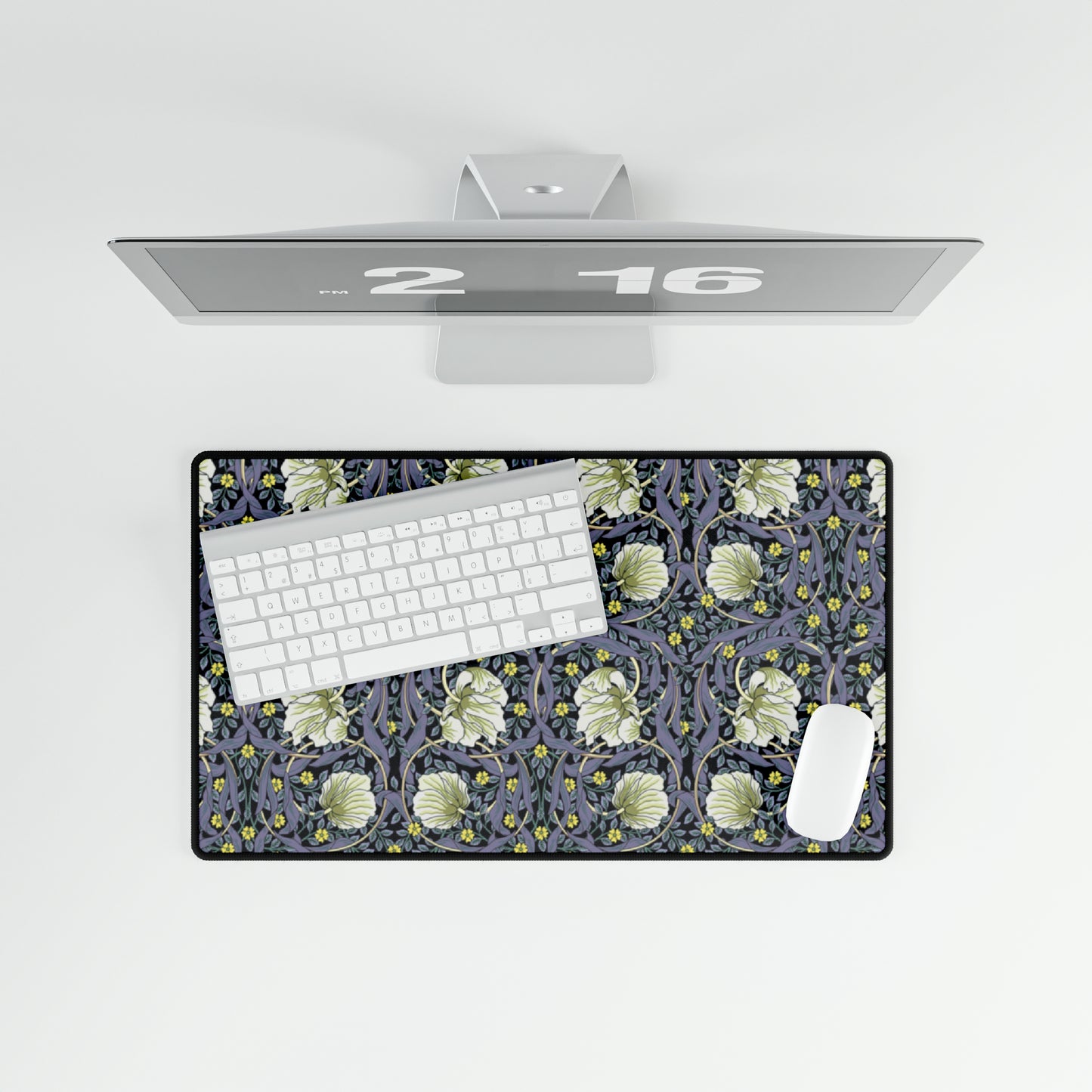 A large desk mat with a floral pattern in shades of purple and green, displayed on a desk with a keyboard and mouse.