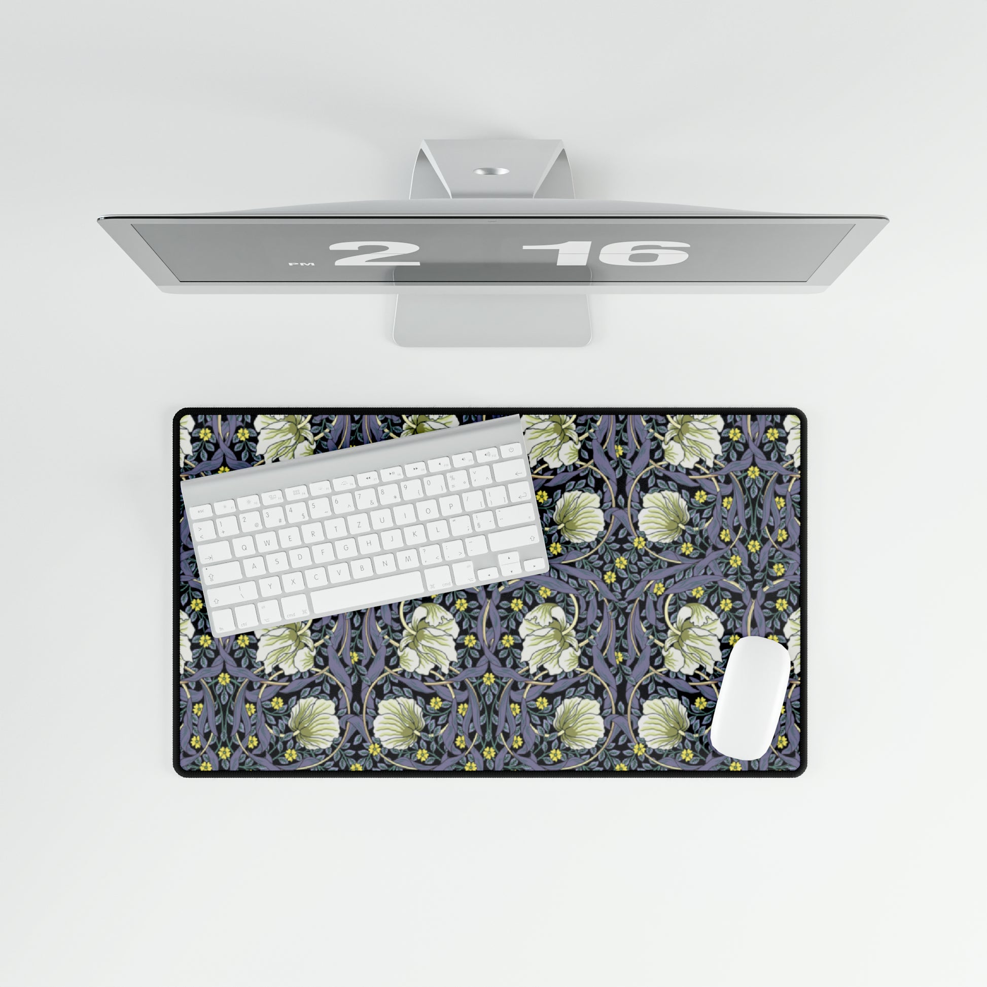 A large desk mat with a floral pattern in shades of purple and green, displayed on a desk with a keyboard and mouse.
