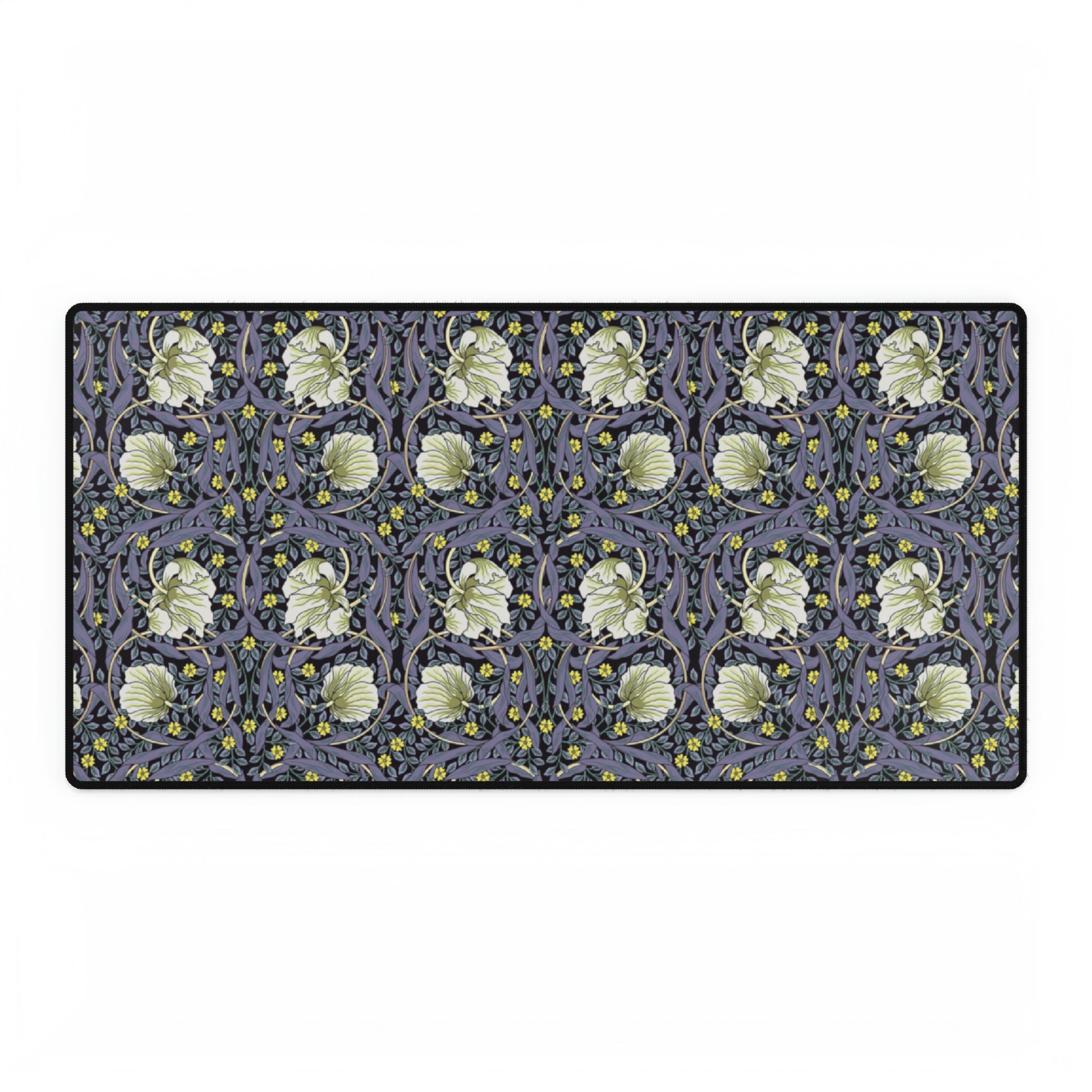 A large desk mat with a William Morris & Co floral pattern in shades of purple and green, displayed on a desk with a keyboard and mouse.