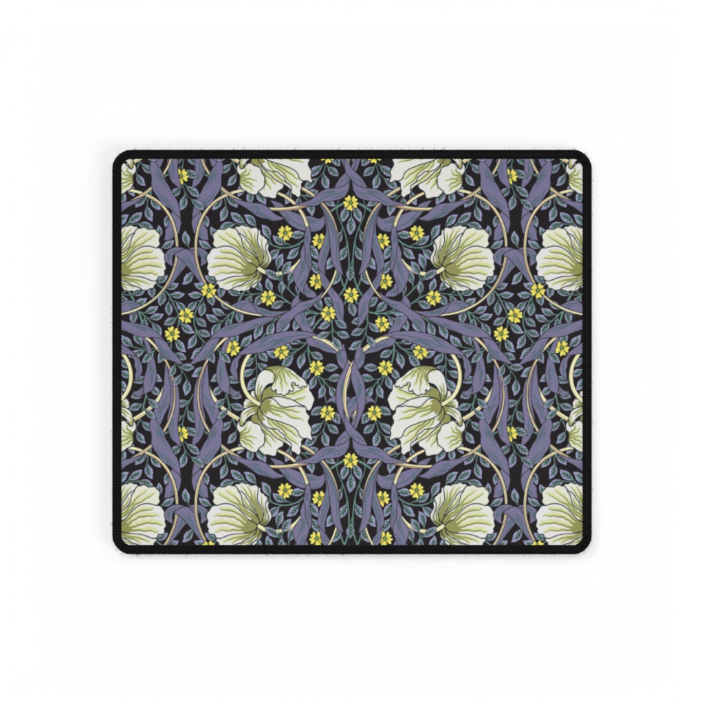 A large desk mat with a William Morris & Co floral pattern in shades of purple and green, displayed on a desk with a keyboard and mouse.