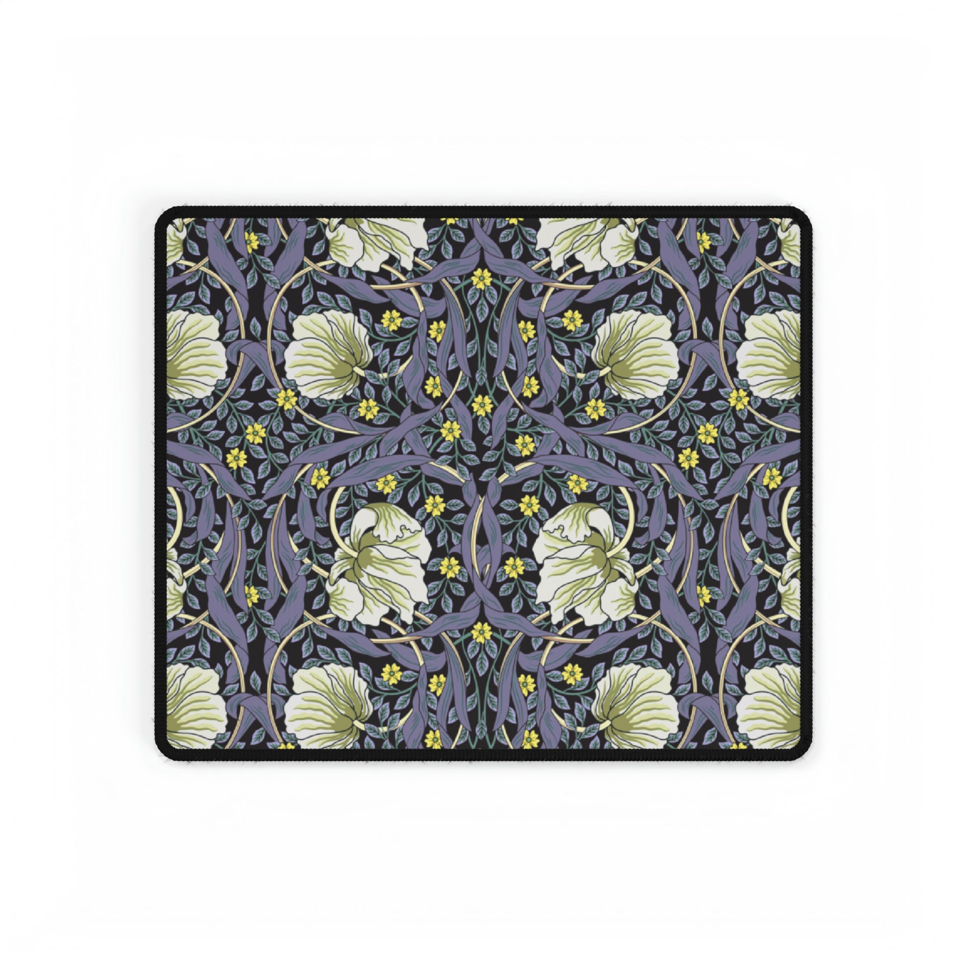 A large desk mat with a William Morris & Co floral pattern in shades of purple and green, displayed on a desk with a keyboard and mouse.
