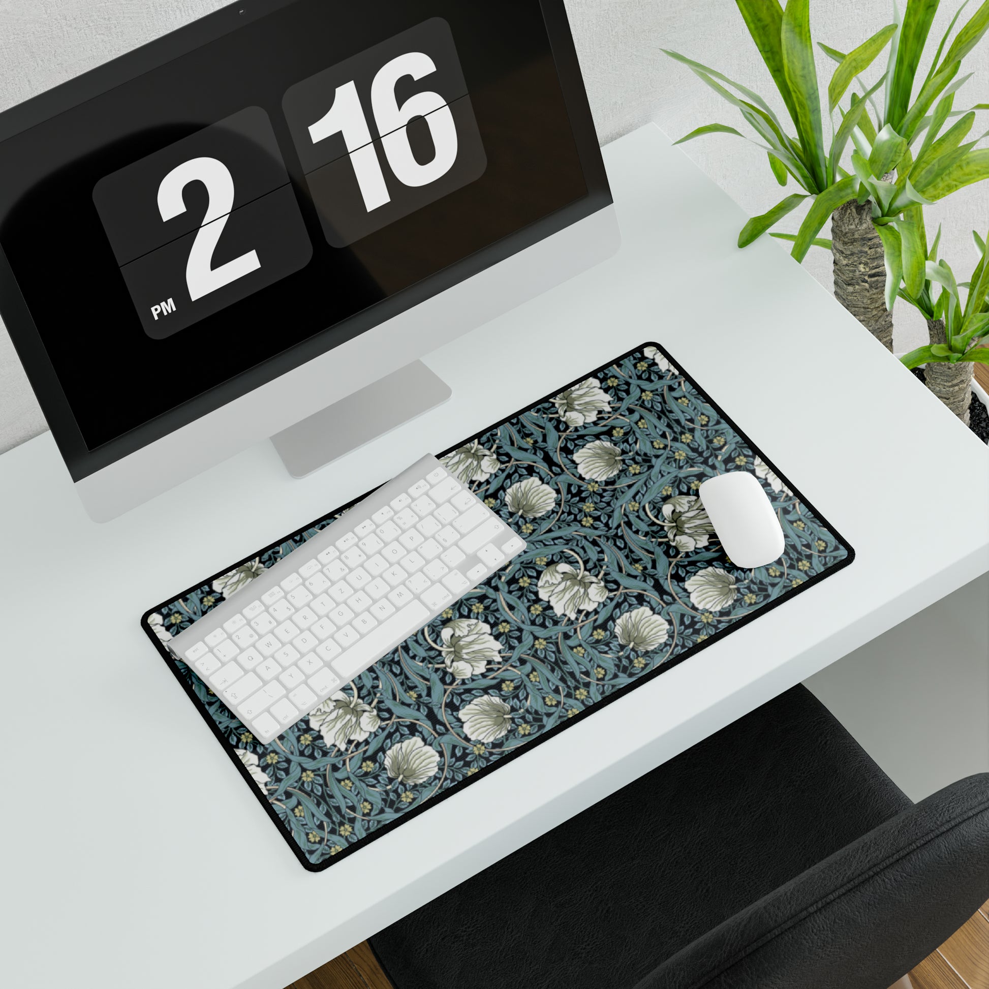 A large desk mat with a William Morris & Co floral pattern in shades of gray and blue, displayed on a desk with a keyboard and mouse.