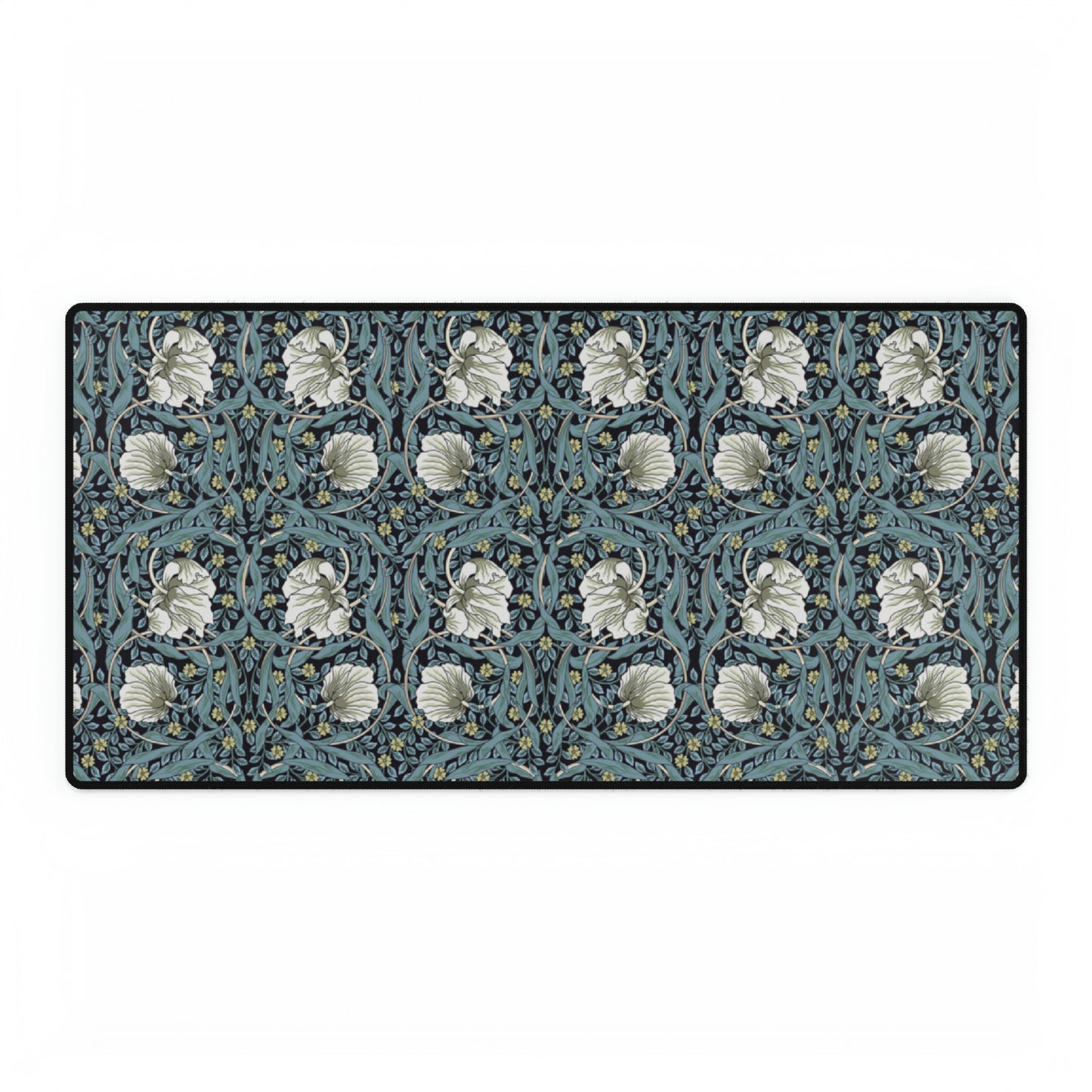 A large desk mat with a William Morris & Co floral pattern in shades of gray and blue, displayed on a desk with a keyboard and mouse.