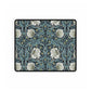 A large desk mat with a William Morris & Co floral pattern in shades of gray and blue, displayed on a desk with a keyboard and mouse.