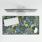 A large desk mat with a blue floral William Morris & Co pattern displayed under a monitor and accompanied by a keyboard and mouse.