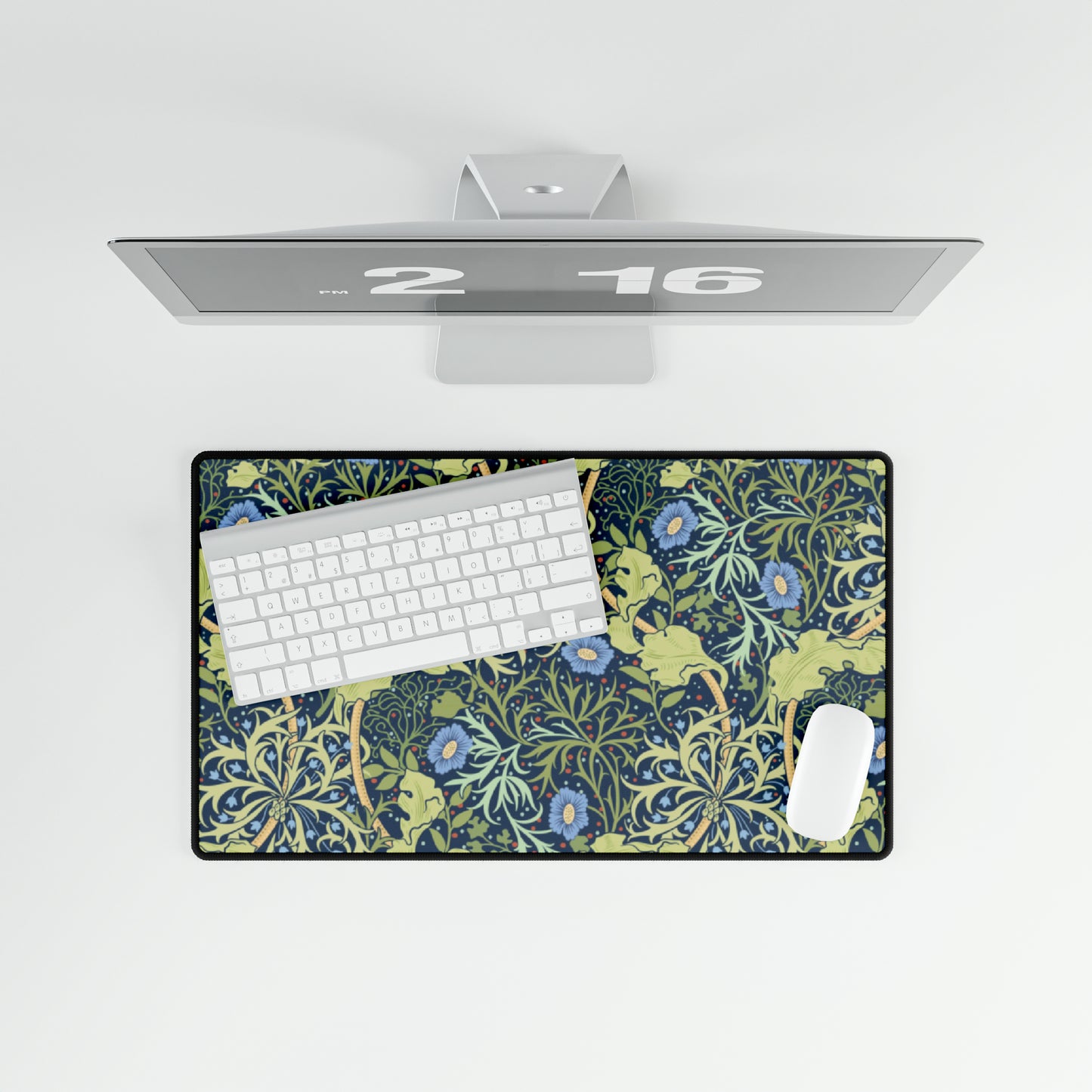 A large desk mat with a blue floral pattern displayed under a monitor and accompanied by a keyboard and mouse.