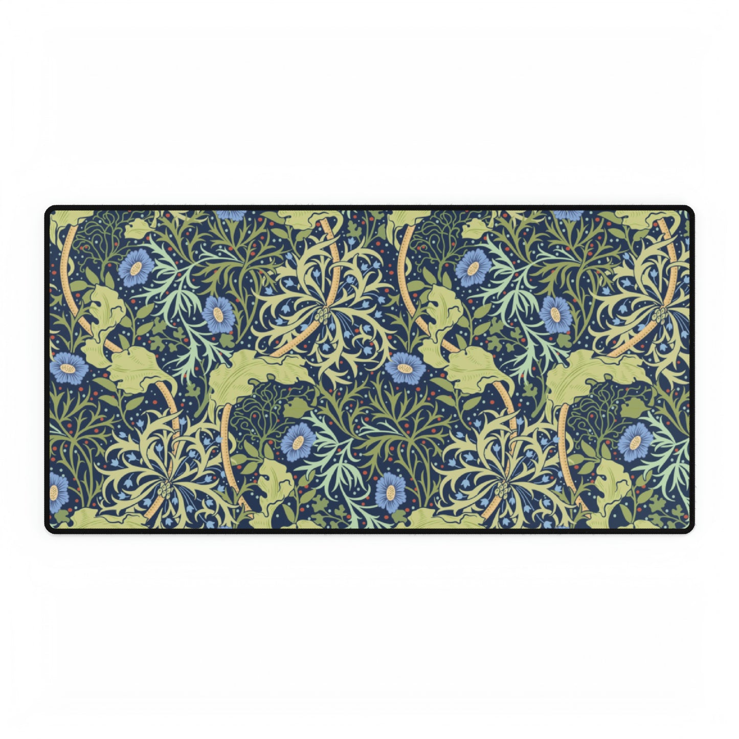 A large desk mat with a blue floral William Morris & Co pattern displayed under a monitor and accompanied by a keyboard and mouse.