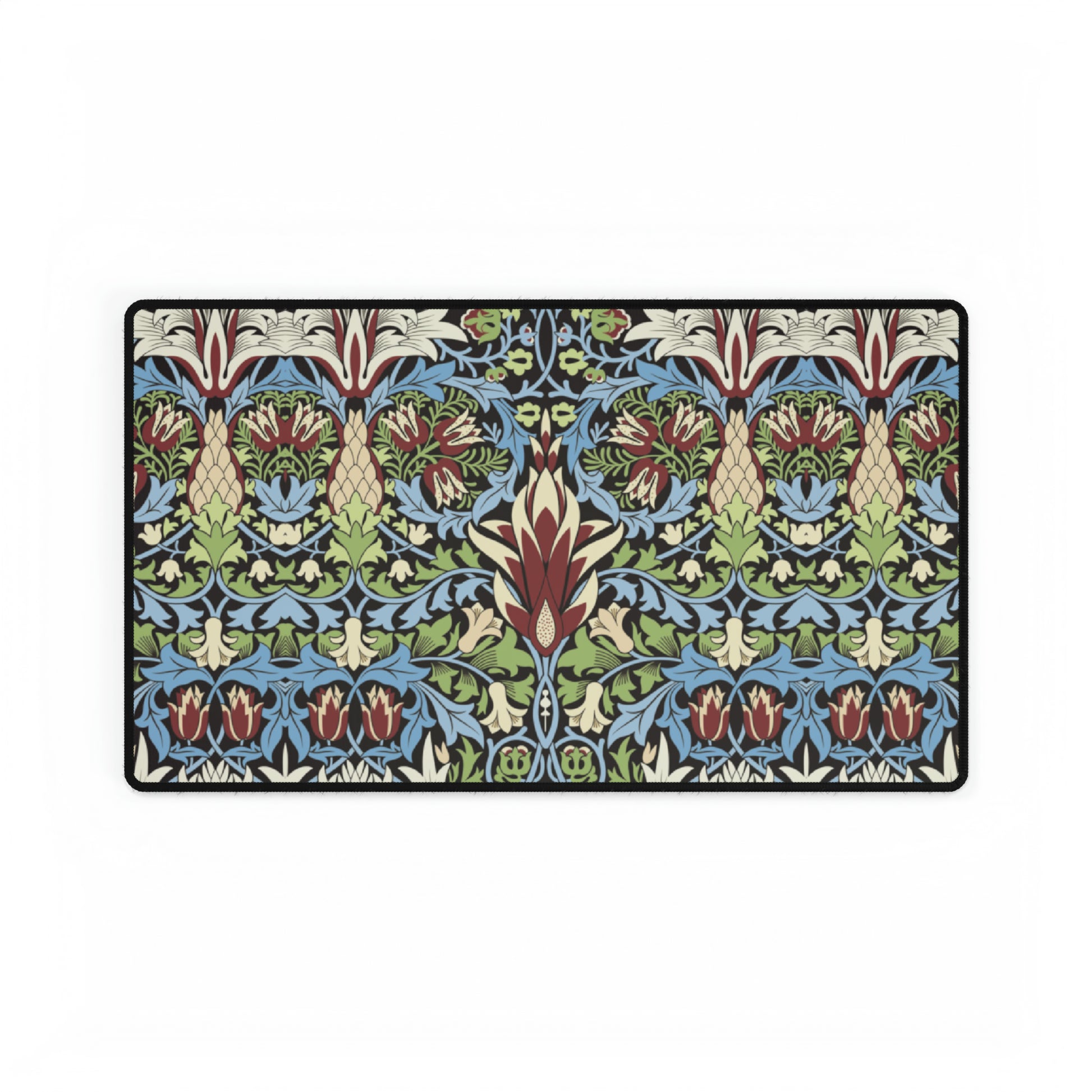 A large, decorative desk mat with a floral and geometric William Morris & Co pattern, displayed on a desk with a keyboard and mouse.