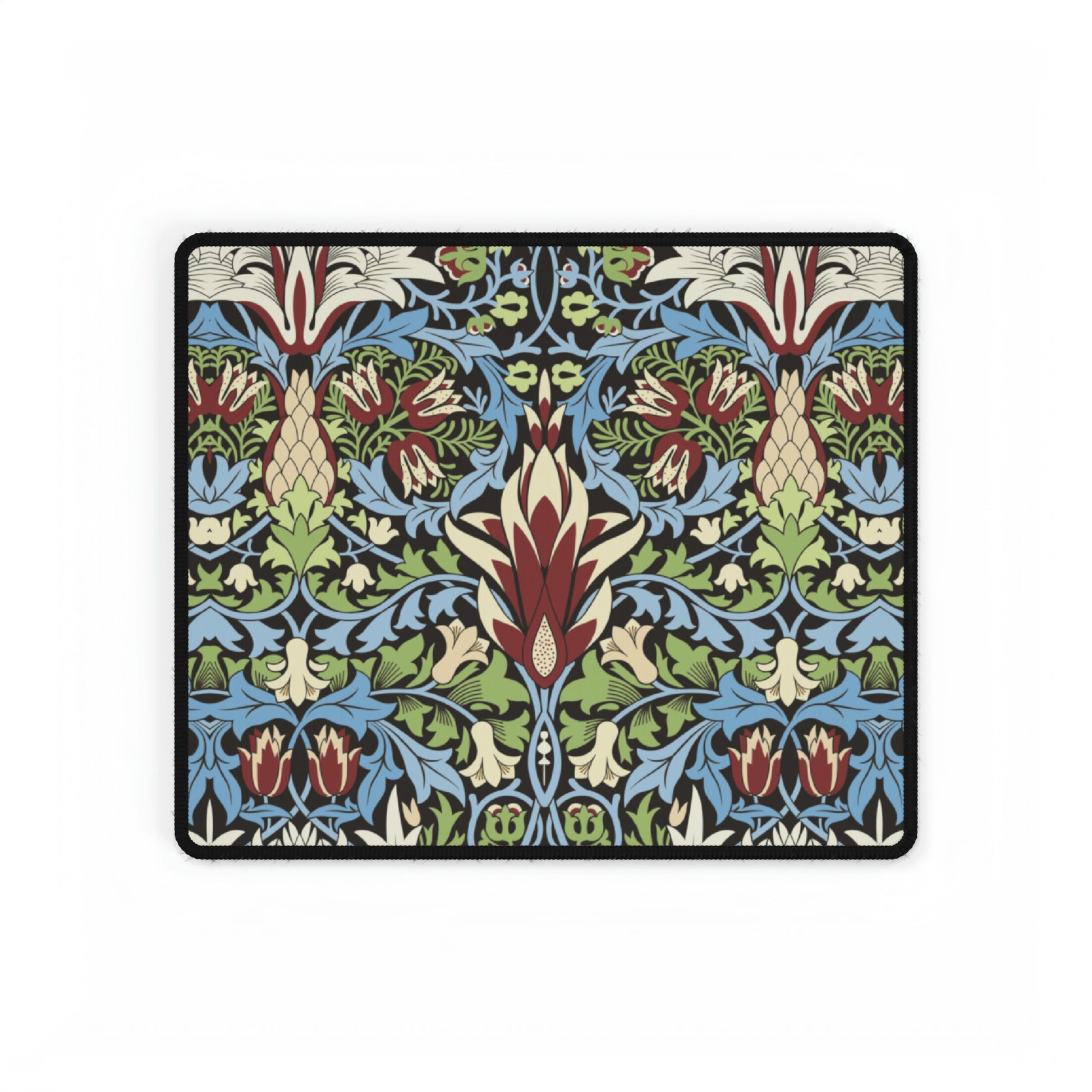 A large, decorative desk mat with a floral and geometric William Morris & Co pattern, displayed on a desk with a keyboard and mouse.