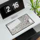 Desk setup with a patterned mouse pad, keyboard, and digital clock displaying '2 PM 16'.