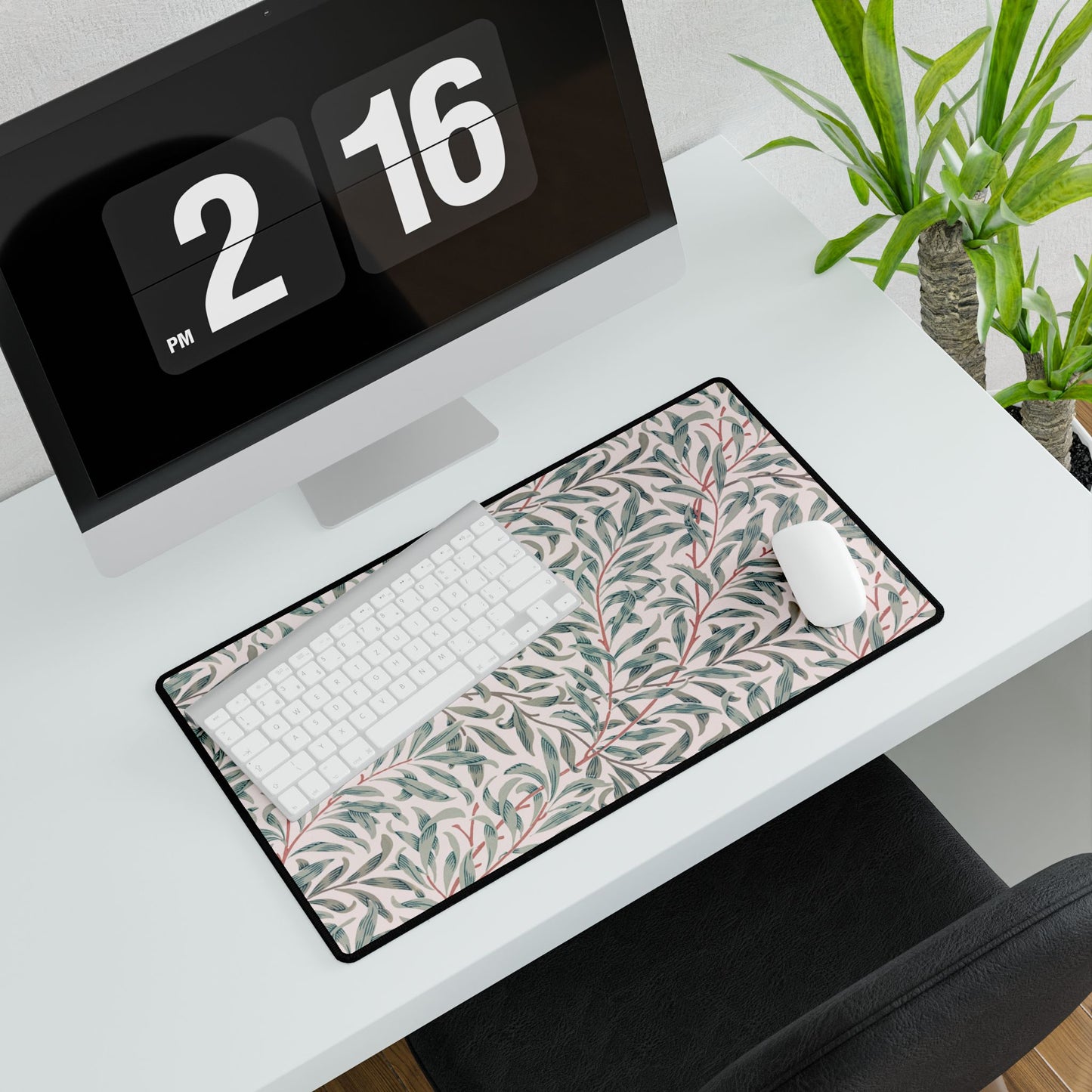 Desk setup with a patterned mouse pad, keyboard, and digital clock displaying '2 PM 16'.