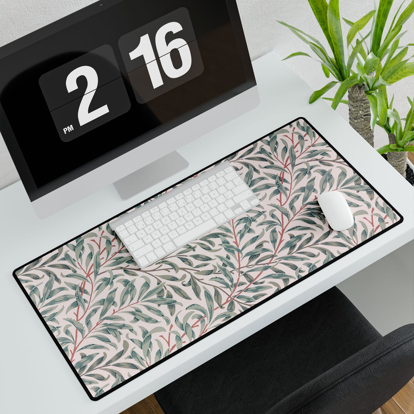 Floral patterned desk mat on a desk with a computer and plants in the background