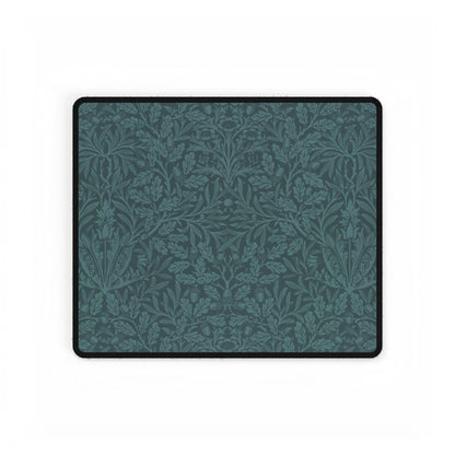 A rectangular desk mat with a teal background and an intricate floral pattern of acorns and oak leaves.