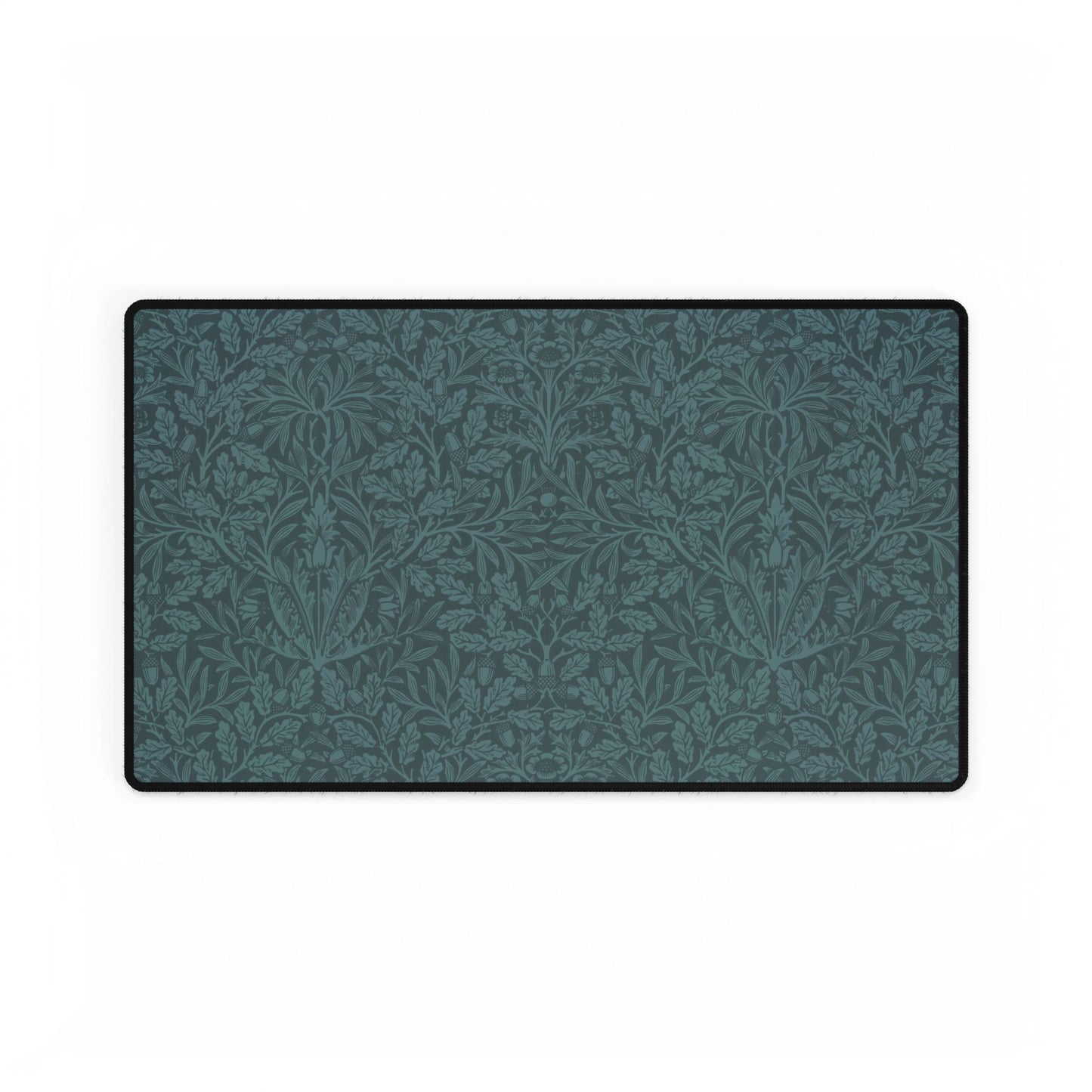 A rectangular desk mat with a teal background and an intricate floral pattern of acorns and oak leaves.