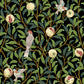 A rectangular desk mat with a floral William Morris & Co pattern featuring birds and pomegranates, placed under a desk with a keyboard and mouse on top.