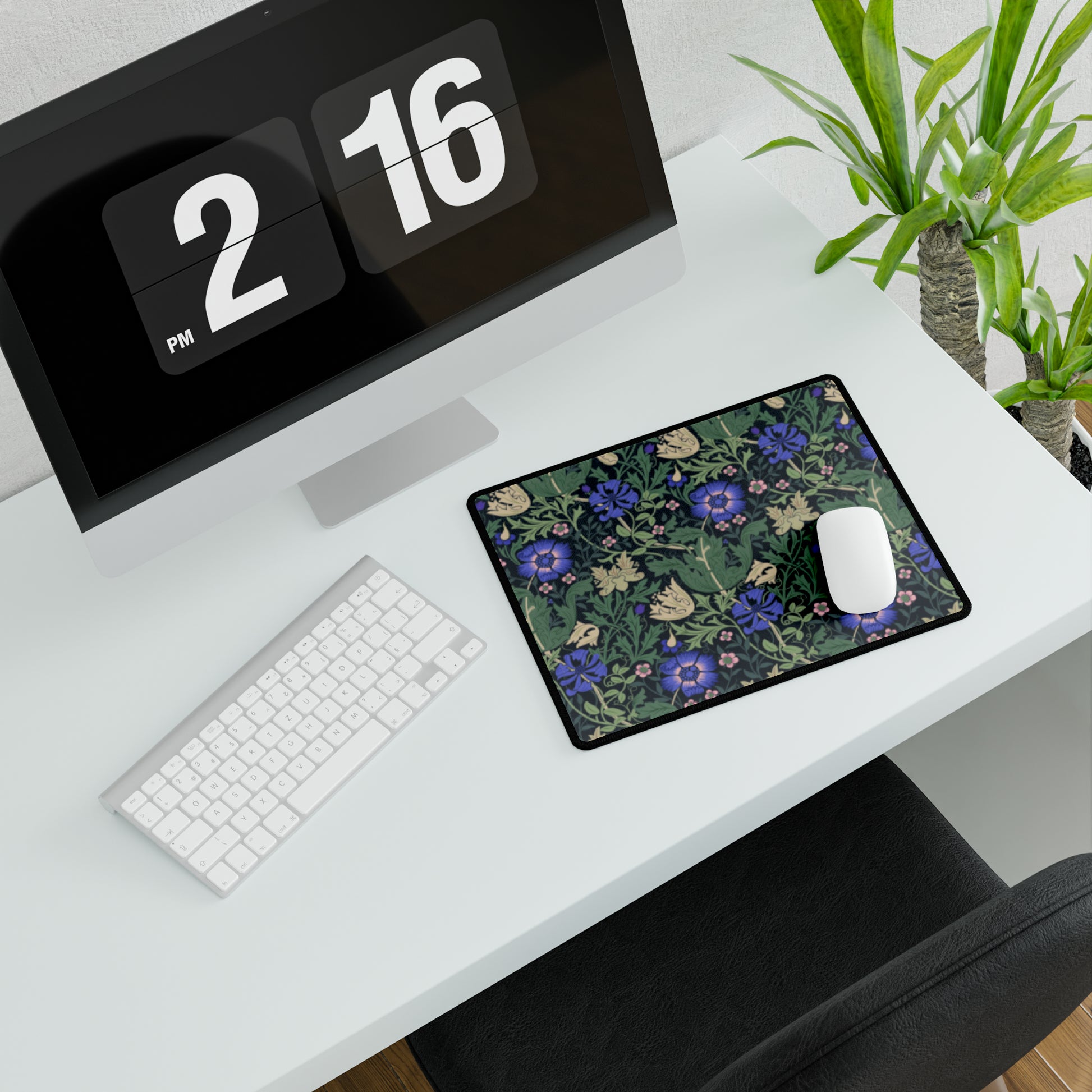 A desk mat with a William Morris & Co floral pattern, featuring a mouse pad on top. The desk mat has a non-slip base and is placed under a shelf with a computer monitor and a keyboard.