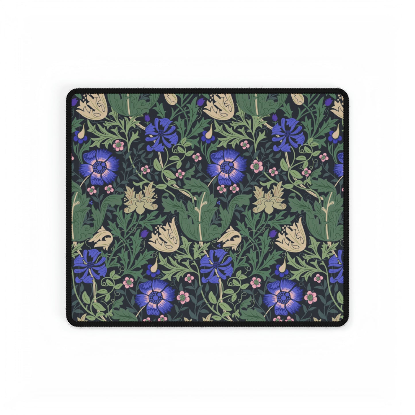 A desk mat with a William Morris & Co floral pattern, featuring a mouse pad on top. The desk mat has a non-slip base and is placed under a shelf with a computer monitor and a keyboard.