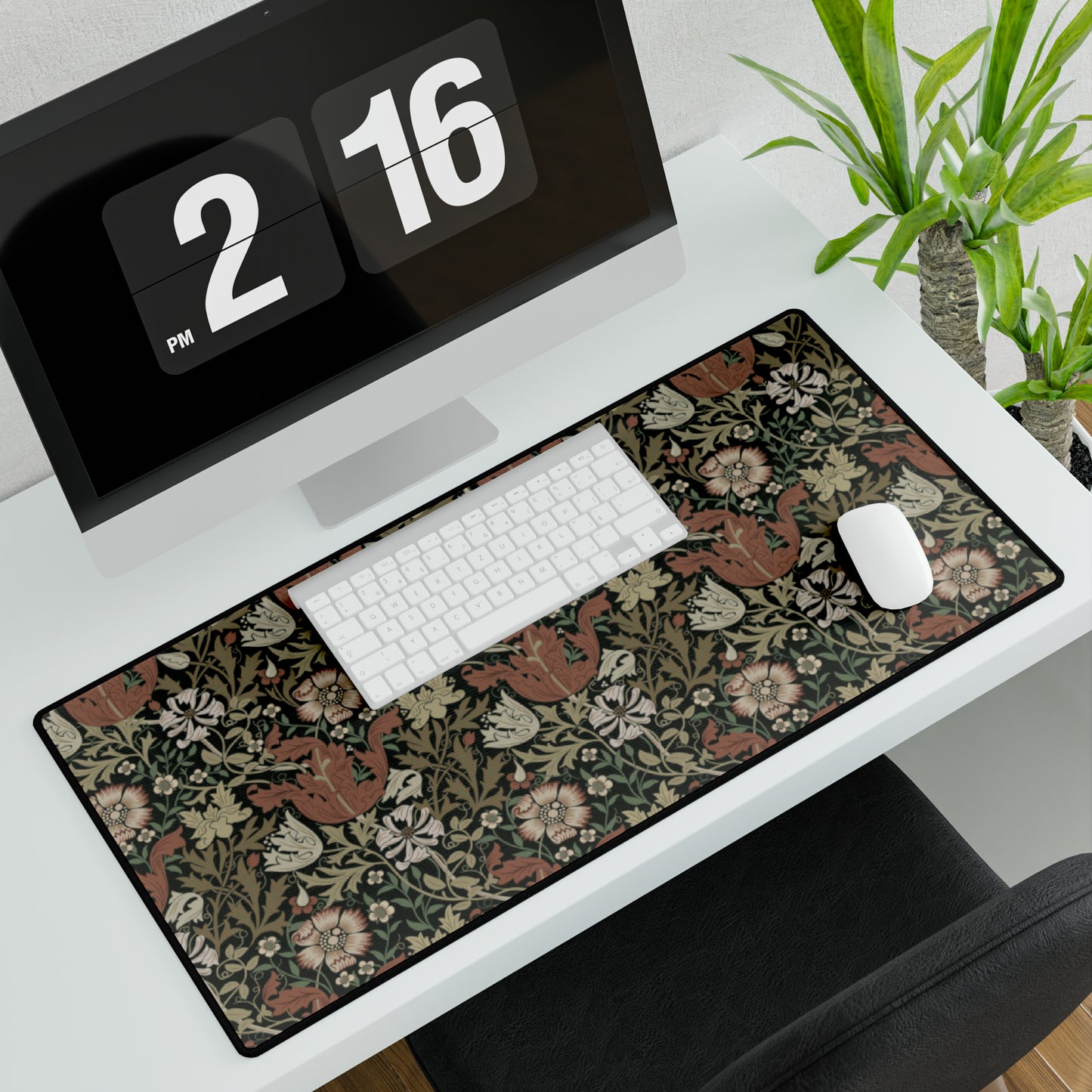 A large, rectangular neoprene desk mat with a William Morris & Co floral pattern, displayed under a computer monitor and keyboard, illustrating its use in a workspace.
