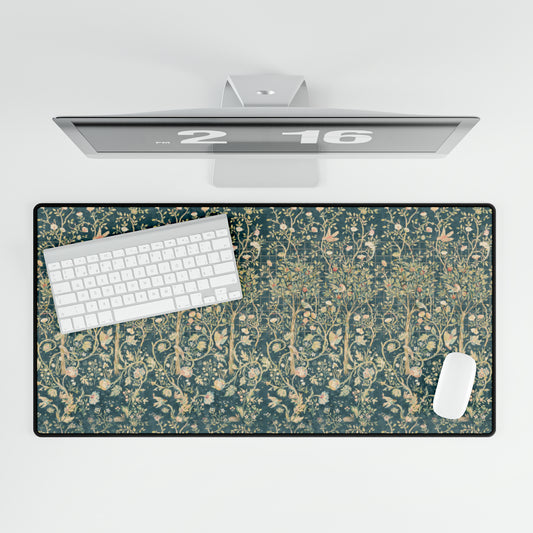 A large desk mat with a floral William Morris & Co pattern in evergreen teal colours, displayed on a desk with a keyboard and mouse.