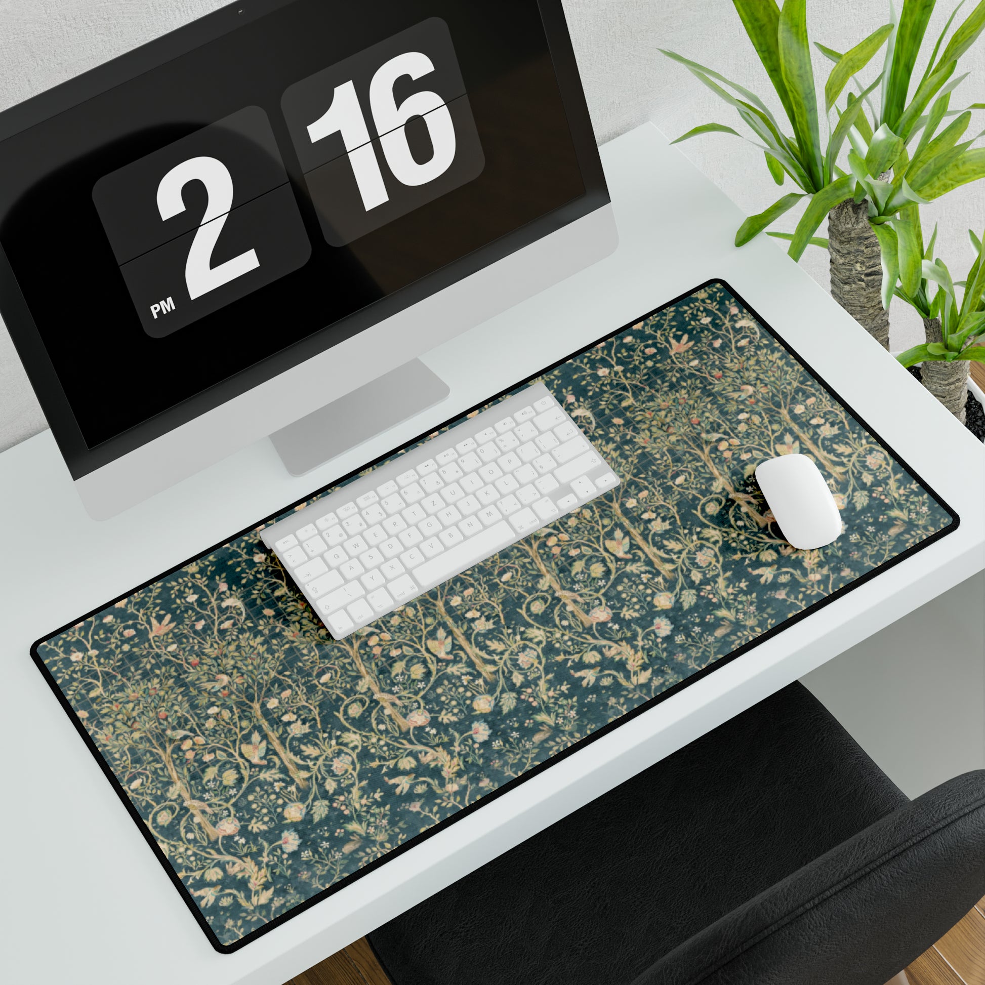 A large desk mat with a floral William Morris & Co pattern in evergreen teal colours, displayed on a desk with a keyboard and mouse.