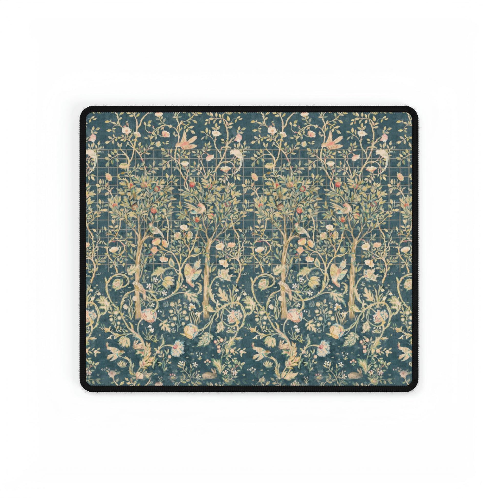 A large desk mat with a floral William Morris & Co pattern in evergreen teal colours, displayed on a desk with a keyboard and mouse.