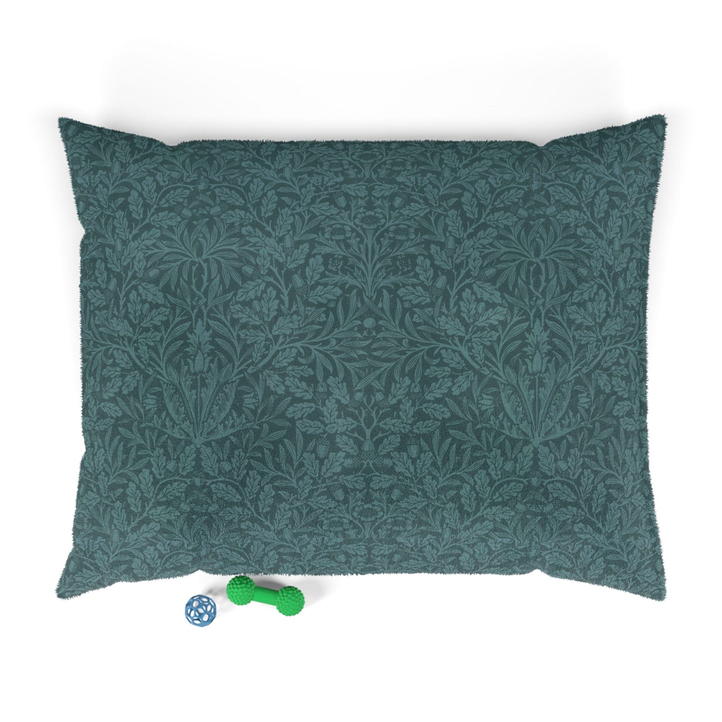 Green patterned dog bed pillow on a white background with two small toys at the bottom.