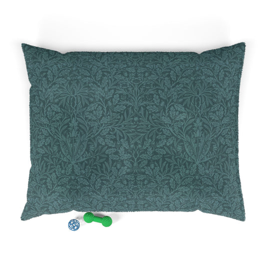 Green patterned dog bed pillow on a white background with two small toys at the bottom.