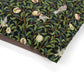 Fabric with a nature-themed pattern featuring leaves, flowers, and birds on a black background.
