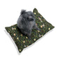 Dog sitting on a William Morris & Co decorative pillow with a green pattern on a white background