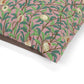 Fabric with a pattern of leaves and pomegranates on a pink background