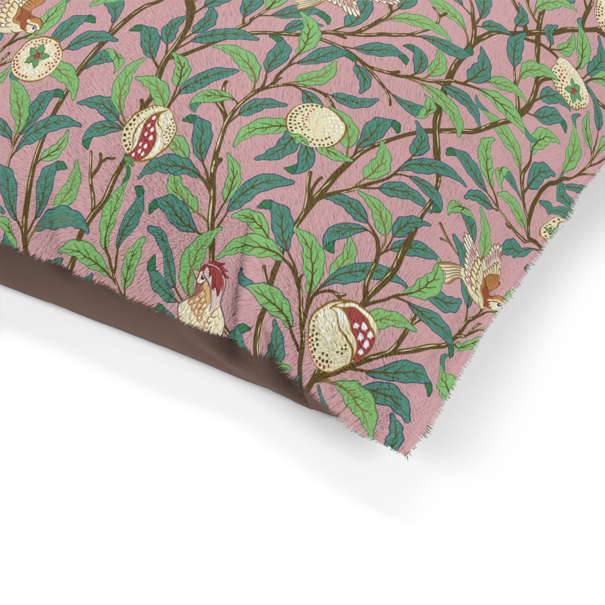 Fabric with a pattern of leaves and pomegranates on a pink background